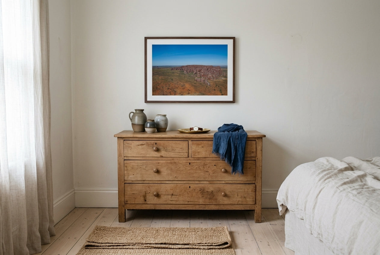 Bungle Bungles From Above, framed above a vintage raw-oak dresser in a master bedroom corner — hand-thrown ceramics, indigo linen, dark wood frame. — Two Fat Bunnies.
