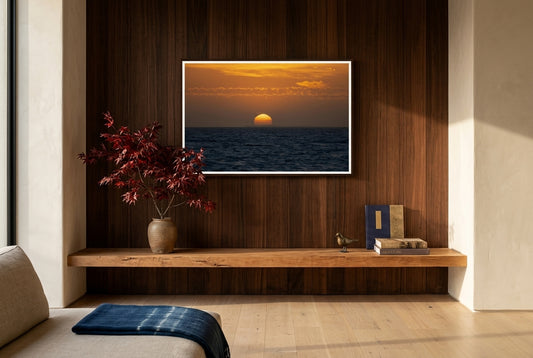 Golden Dusk: Sunset Over Port Phillip Bay, Melbourne, framed above a low cedar mantel-console in an Australian-Japanese fusion living room — ikebana, cedar feature wall, oat linen sofa, dark wood frame. — Two Fat Bunnies.