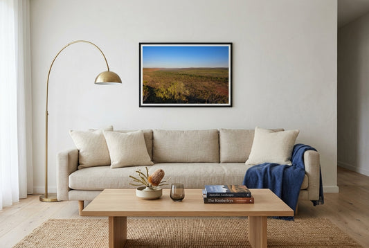 Golden Hour Across El Questro, Buddy's Lookout, framed in a modern Australian living room — oat linen sofa, woven jute rug, low oak coffee table, brass arc lamp, dark wood frame. — Two Fat Bunnies.