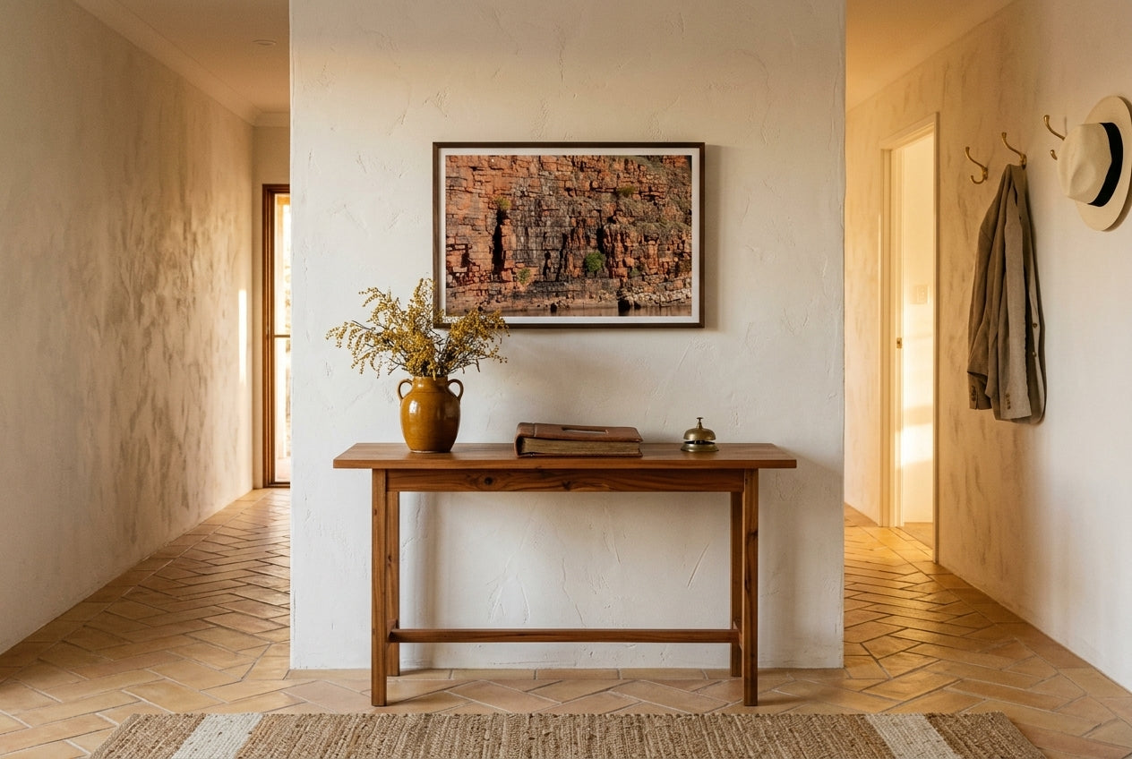 Golden Strata, Chamberlain Gorge, framed above a slim cedar console in a contemporary Australian hallway — honey terracotta tile, dried wattle, brass coat hooks, dark wood frame. — Two Fat Bunnies.