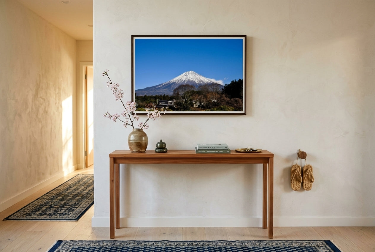 Majestic Mount Fuji, framed above a slim cedar console in an Australian-Japanese fusion entry hall — indigo-cream runner rug, cherry blossom ikebana, woven straw zori, dark wood frame. — Two Fat Bunnies.