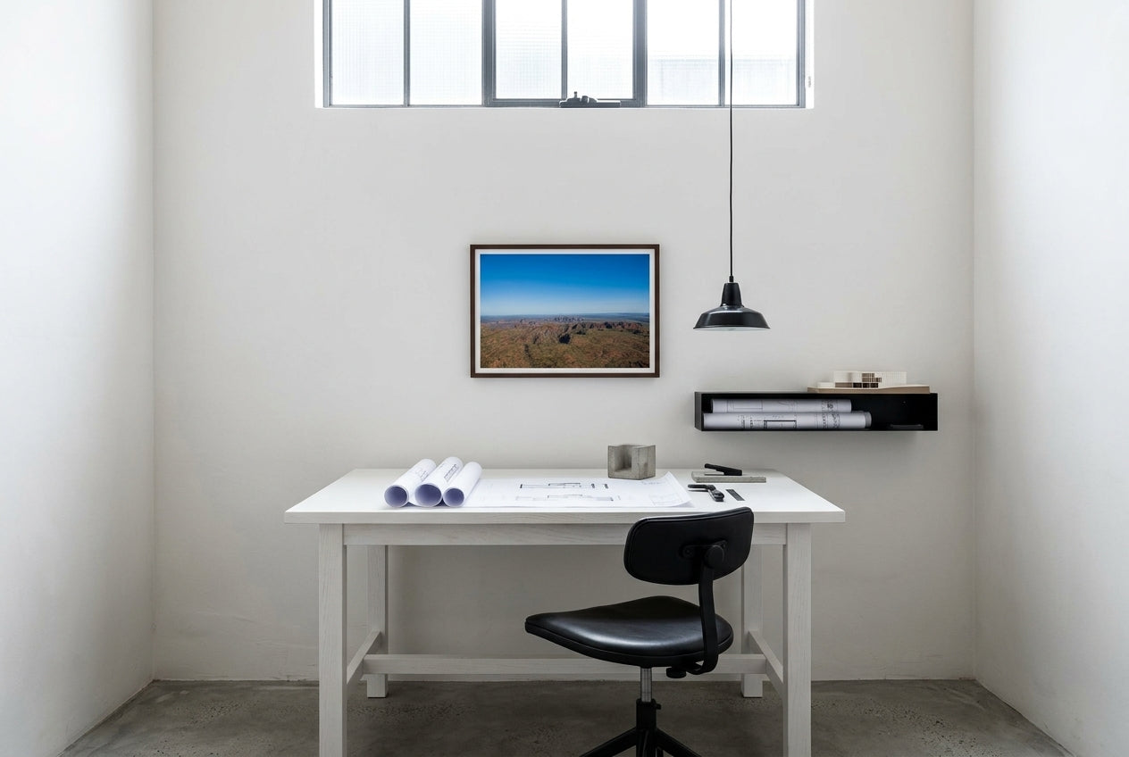 Beehive Domes from Above, framed above a white-painted oak drafting table in an architect's compact home studio — polished concrete floor, black task chair, industrial pendant, dark wood frame. — Two Fat Bunnies.