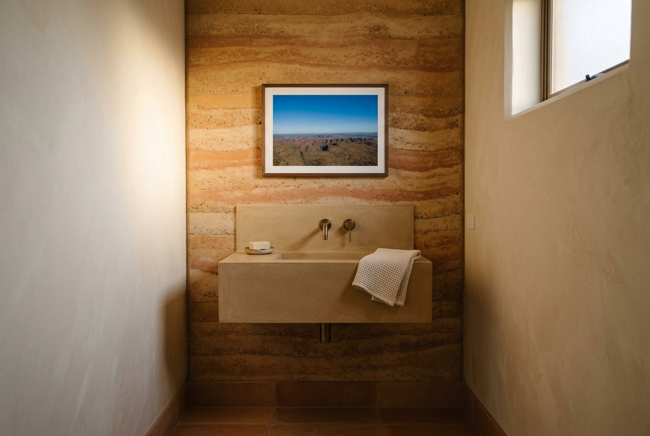 Beehive Domes from Above, framed in a small contemporary Australian powder room — rammed-earth feature wall, polished concrete vanity, brass tap, dark wood frame. — Two Fat Bunnies.