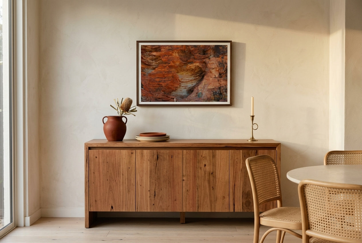 Beehive Patterns, framed above a spotted-gum sideboard in a refined Melbourne dining nook — terracotta vessel, dried banksia, late-afternoon light, dark wood frame. — Two Fat Bunnies.