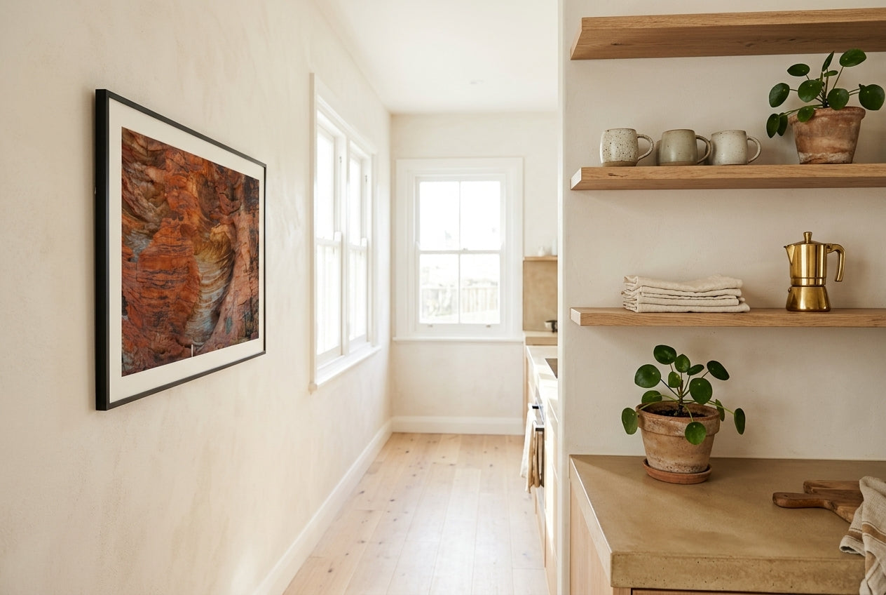 Beehive Patterns, framed beside open raw-oak shelving in a designer Australian kitchen — concrete benchtop, ceramic mugs, brass espresso pot, dark wood frame. — Two Fat Bunnies.