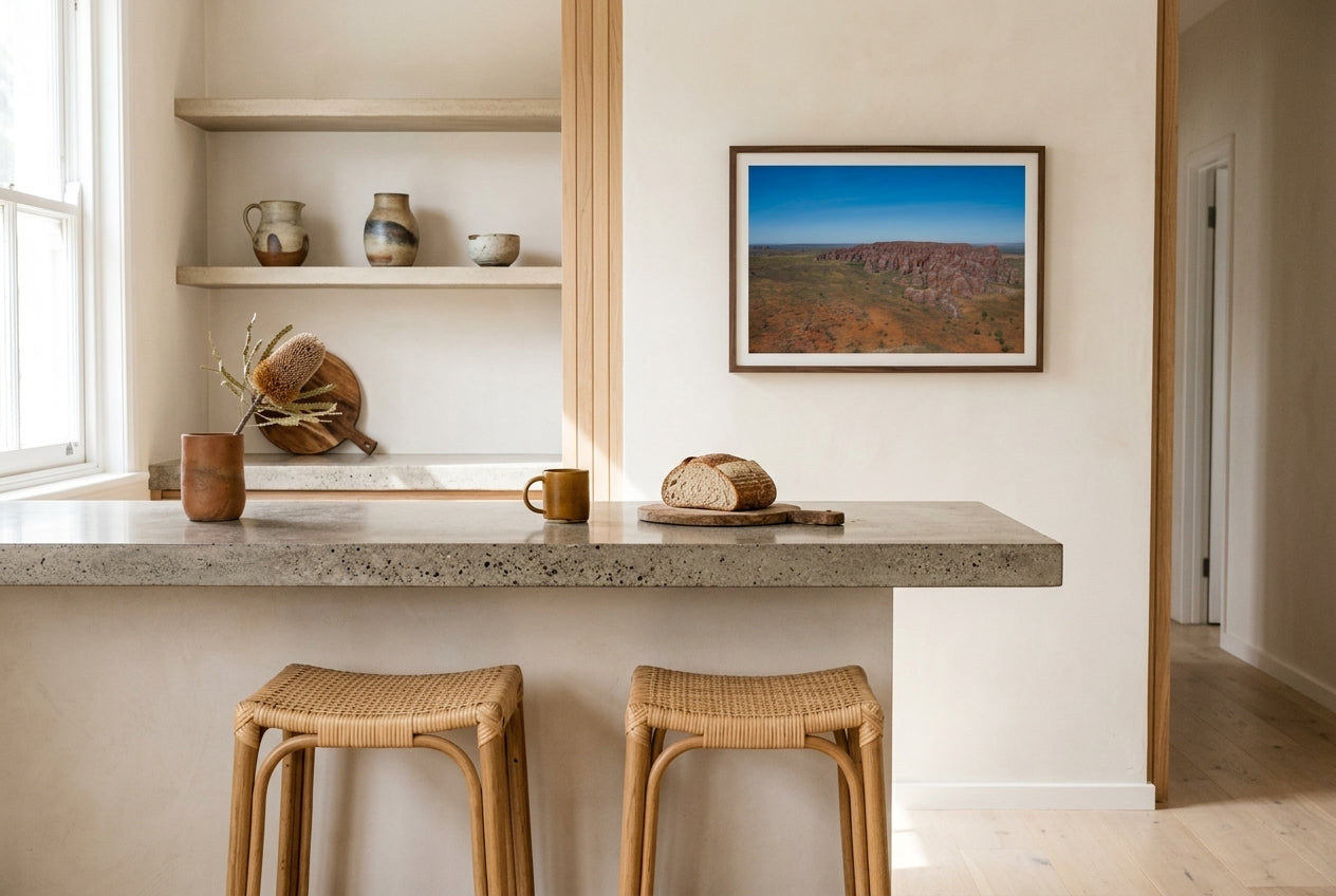 Bungle Bungles From Above, framed above a polished concrete kitchen counter in a designer Australian kitchen — oak-and-rattan stools, raw oak feature wall, dried banksia, dark wood frame. — Two Fat Bunnies.