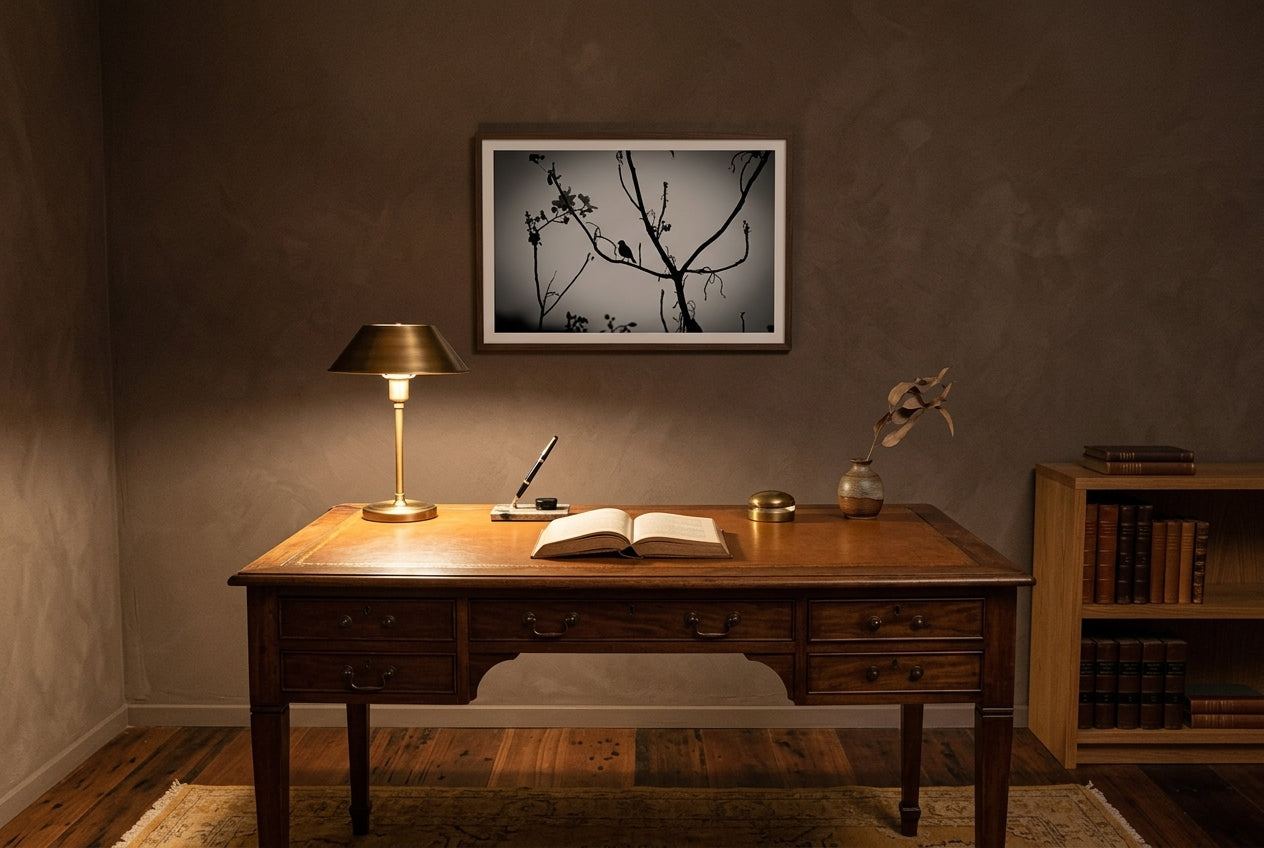 Dusk Solitude — El Questro Bird Silhouette, framed above an aged walnut writing desk in a contemplative home study — deep tan-leather inlay, brass-shaded reading lamp, faded ochre kilim, dark wood frame. — Two Fat Bunnies.