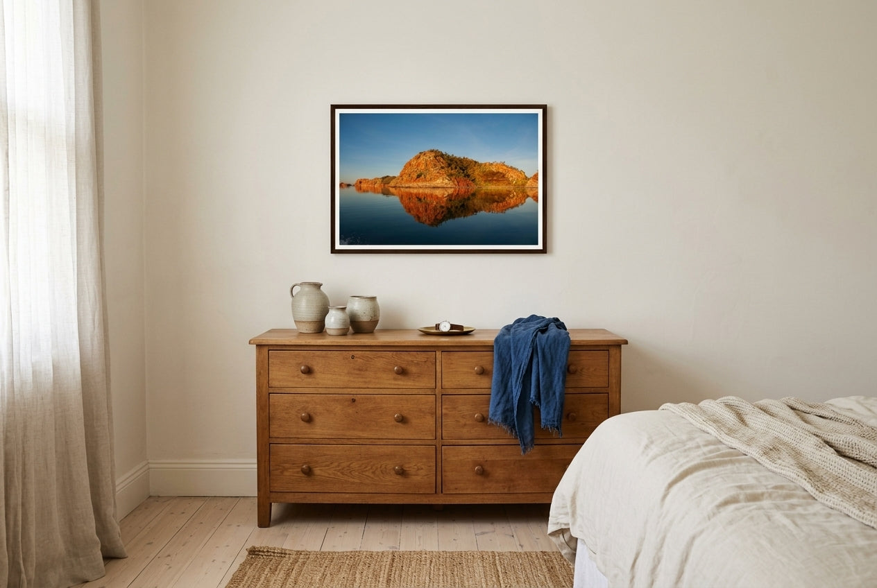 Golden Hour Mirror — Island Reflections, Lake Argyle, framed above a vintage oak dresser in a master bedroom corner — hand-thrown ceramics, indigo linen scarf, dark wood frame. — Two Fat Bunnies.