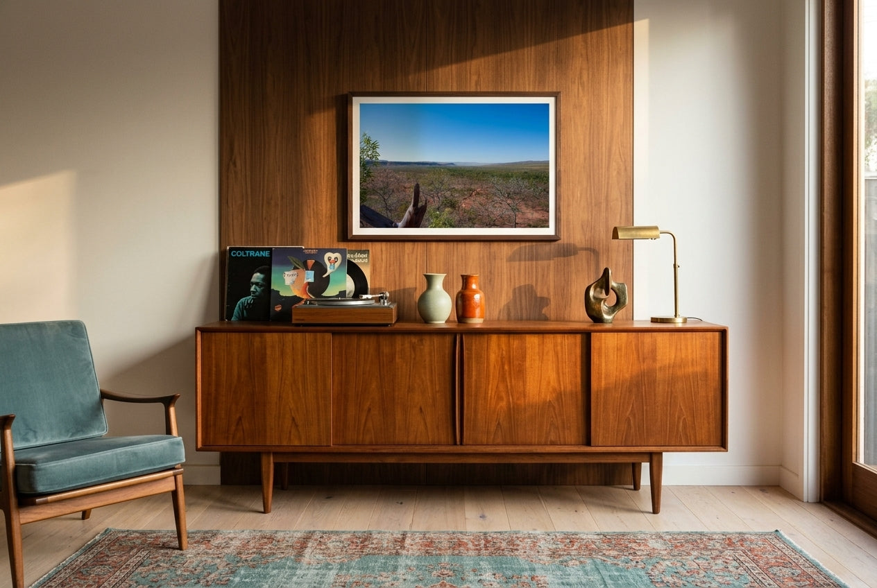 Kimberley Horizon — El Questro Lookout, framed above a long mid-century teak credenza in a Melbourne living room — hi-fi speakers, ceramic vase, modernist accents, dark wood frame. — Two Fat Bunnies.