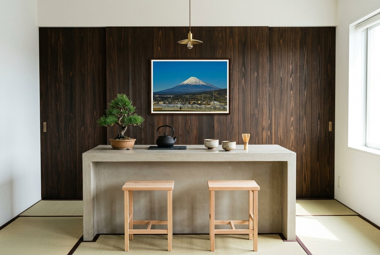 Mt Fuji in Motion: Shinkansen View, framed above a polished concrete kitchen counter in a Japanese-modern kitchen — cedar feature wall, slim cedar stools, bonsai pine, cast-iron tea kettle, dark wood frame. — Two Fat Bunnies.