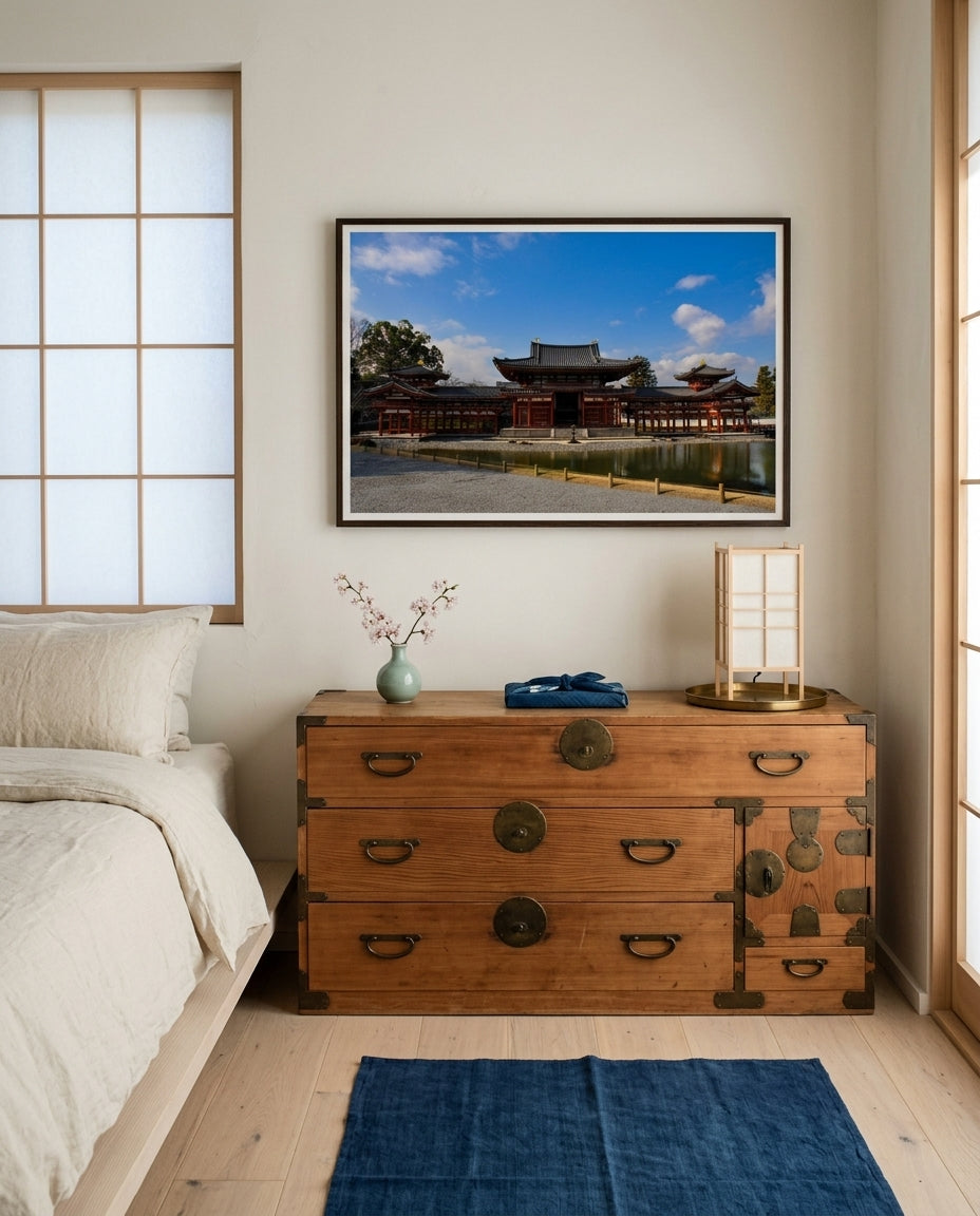 Phoenix Hall Serenity – Byōdō-in Temple, Kyoto, framed above a Japanese tansu chest in a Japandi bedroom — cream linen platform bed, indigo throw, paper lamp, dark wood frame. — Two Fat Bunnies.