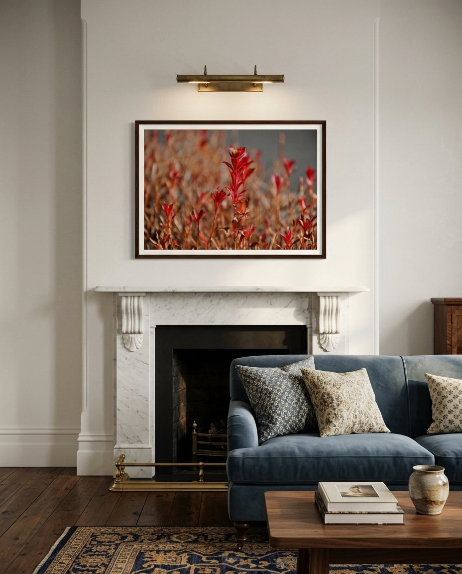 Radiant Red Bloom – Tokyo Roadside Flower, framed above a fireplace in a formal living room — marble surround, neutral upholstery, brass candlesticks, dark wood frame. — Two Fat Bunnies.