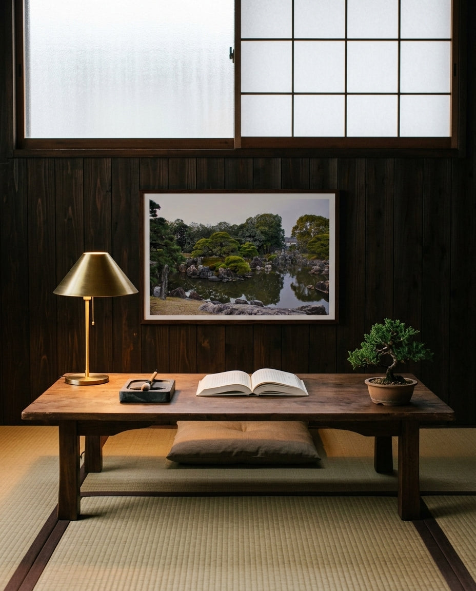 Serenity in Stone: Japanese Garden at Nijo Castle, Kyoto, framed above a Japanese writing desk under a window — paper-shaded lamp, ink stone and brush, ceramic tea bowl, dark wood frame. — Two Fat Bunnies.
