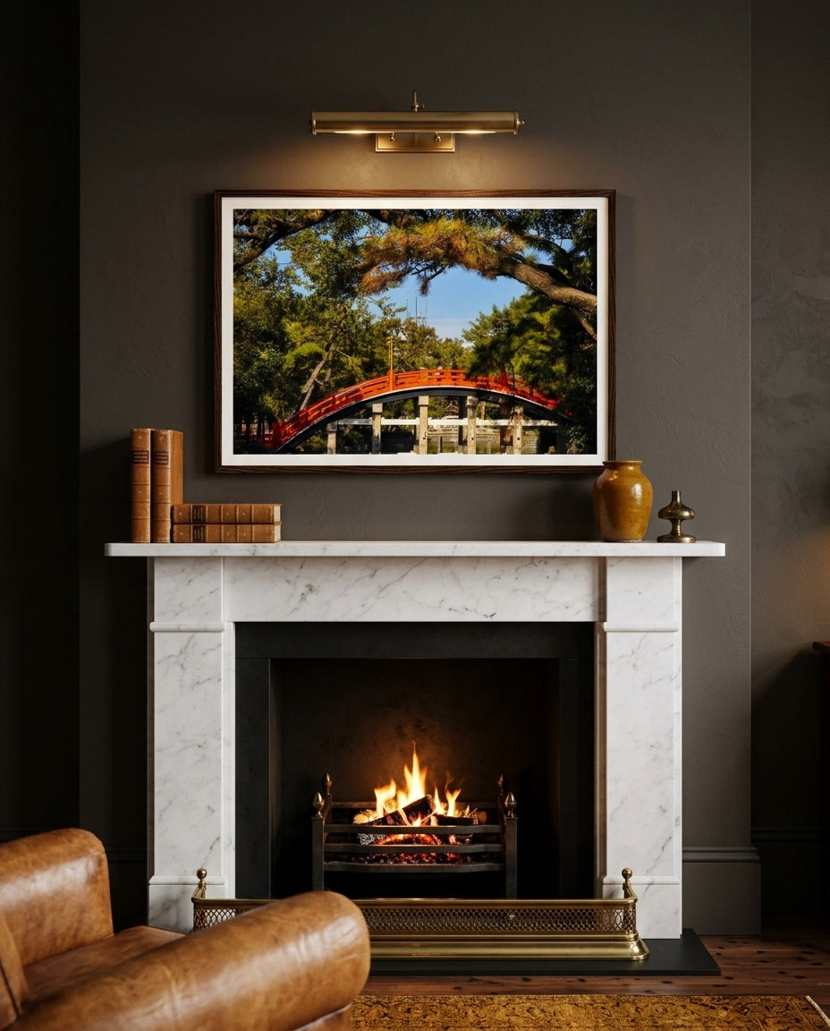 Sumiyoshi Taisha Bridge – Vibrant Japanese Shrine Art, framed above a charcoal-plaster fireplace in a quiet snug — deep linen armchair, woven wool throw, brass candlestick, stacked hardback books, dark wood frame. — Two Fat Bunnies.
